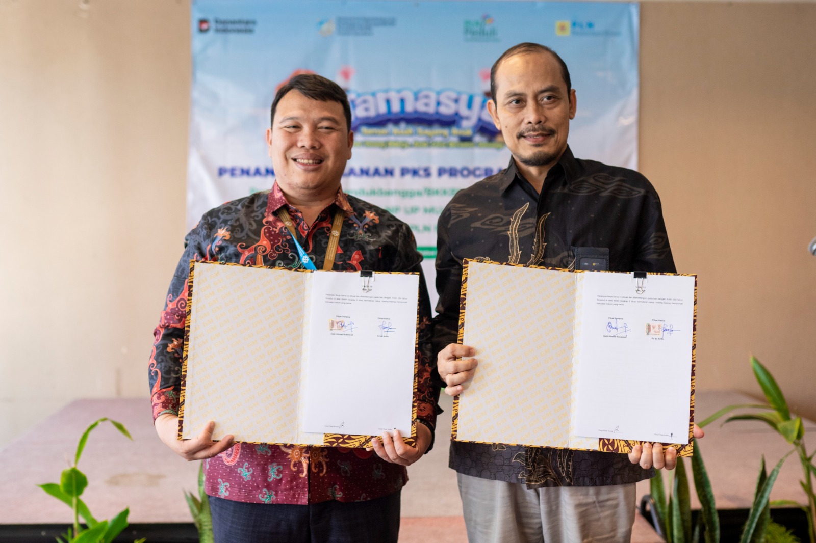 Kepala Perwakilan BKKBN Provinsi Jawa Barat Dr. Dadi Ahmad Roswandi, M.Si (kiri) bersama dengan Senior Manager PLN NP Unit Pembangkitan Indramayu Fu'ad Arifin (kanan) menunjukan naskah perjanjian kerja sama dalam program TAMASYA pada TPA Hommy Motty Daycare seusai ditandatangani pada Jumat (10/10) di Bekasi.