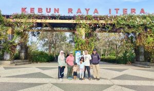 Pengunjung berfoto di depan Gerbang Utama Kebun Raya ITERA, Jati Agung, Lampung Selatan. Kawasan konservasi seluas 75,52 hektare ini mengusung misi penyelamatan flora dataran rendah (pamah) Sumatera. | Dok. Endah Susilowati 